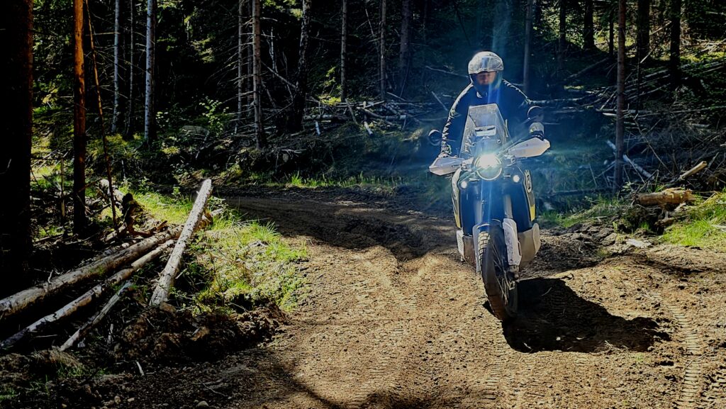 Motorsyklist kjører gjennom skogssti med lys på – del av offroad-trening./ Adventureskolen / Speed Motorcenter / Kjørekurs MC / Motorsykkel