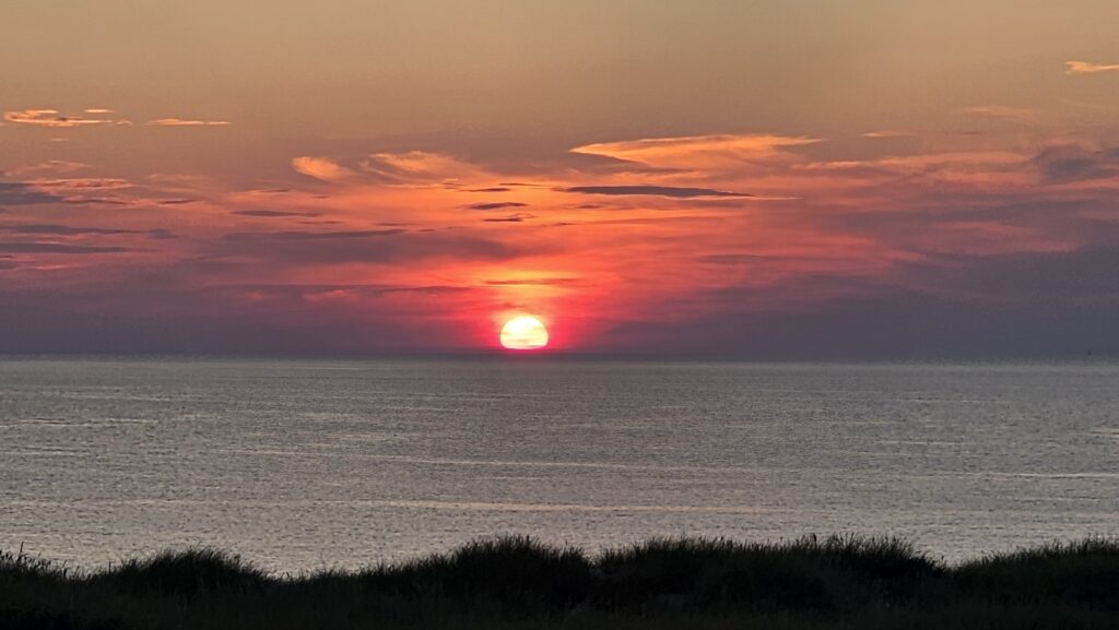 Solnedgang over havet utenfor Løkken. Kenny og Arkitekten nyter et romantisk øyeblikk etter en lang dag på veien./ Speed Motorcenter / SpeedMC / Kyrre Hagen / MC-tur / MC-ferie / Motorsykkel / MC