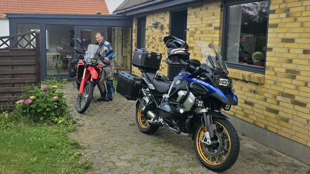 Kenny og Arkitekten foran det typiske danske huset de har fått låne – med to fullastede motorsykler klare for nye kilometer på TET’en./ Speed Motorcenter / SpeedMC / Kyrre Hagen / MC-tur / MC-ferie / Motorsykkel / MC