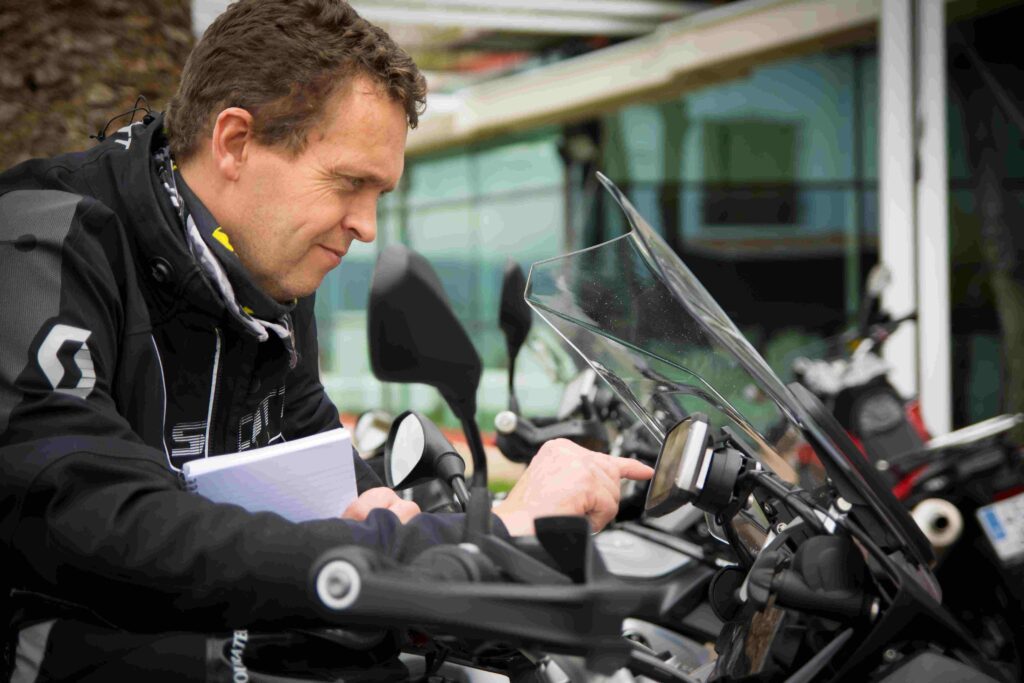 Mann som taster inn navigasjonsrute på motorsykkel, speed motorcenter, sandefjord, mc, adventureskolen 